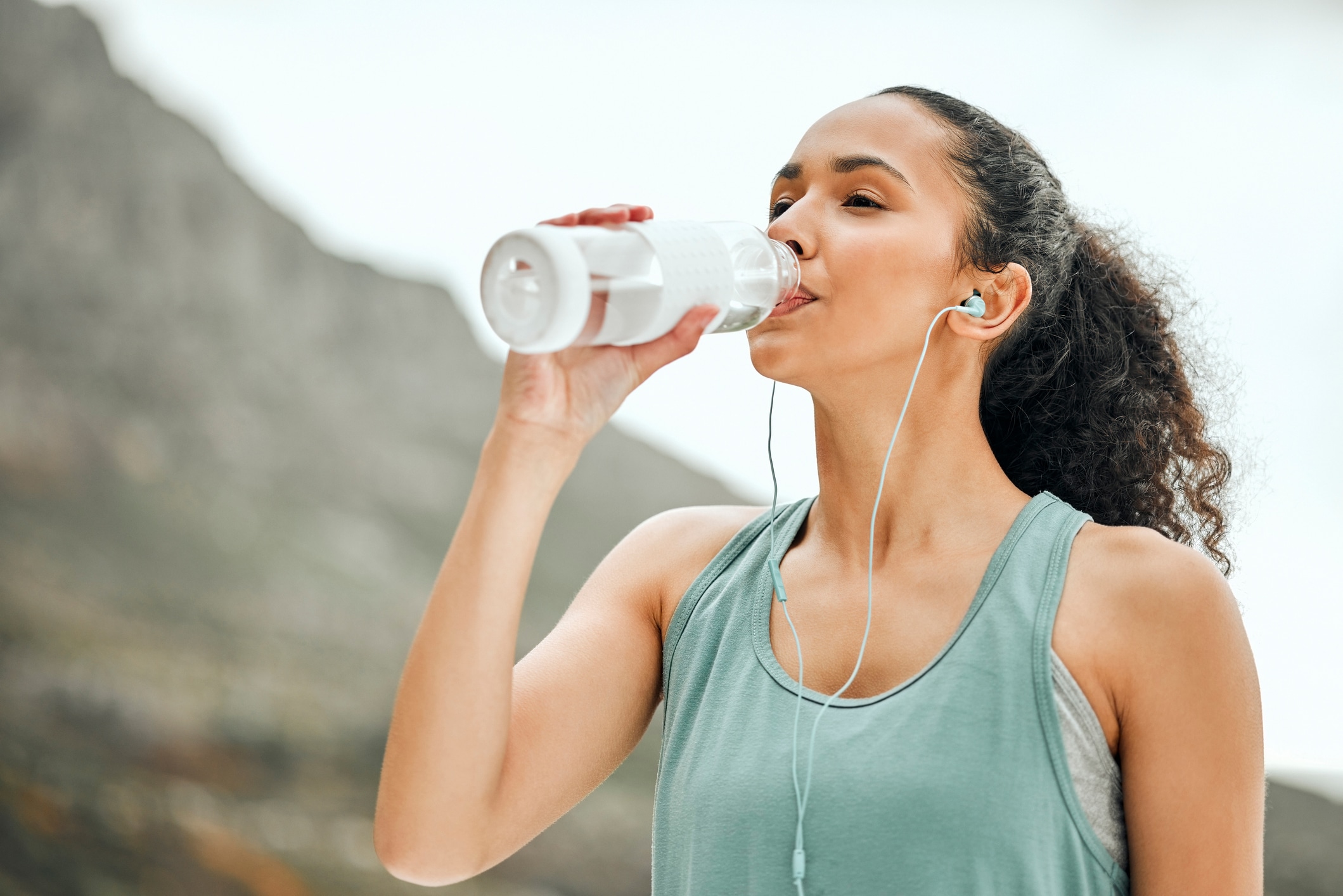 woman drinking water after learning how to stay hydrated in the summer